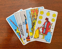 Tarot cards fanned out, with Six of Pentacles on top